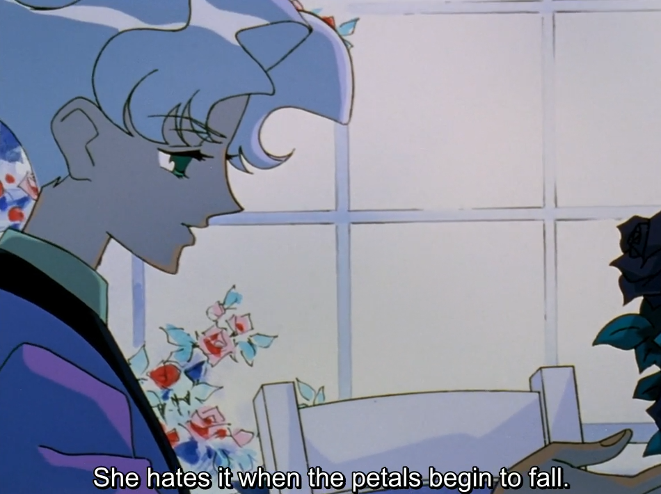A blue-tinted flashback: a young man with pale lavender hair and green eyes looks down in profile in front of a window, as a hand holds out a dark rose. The subtitle reads “She hates it when the petals begin to fall.”